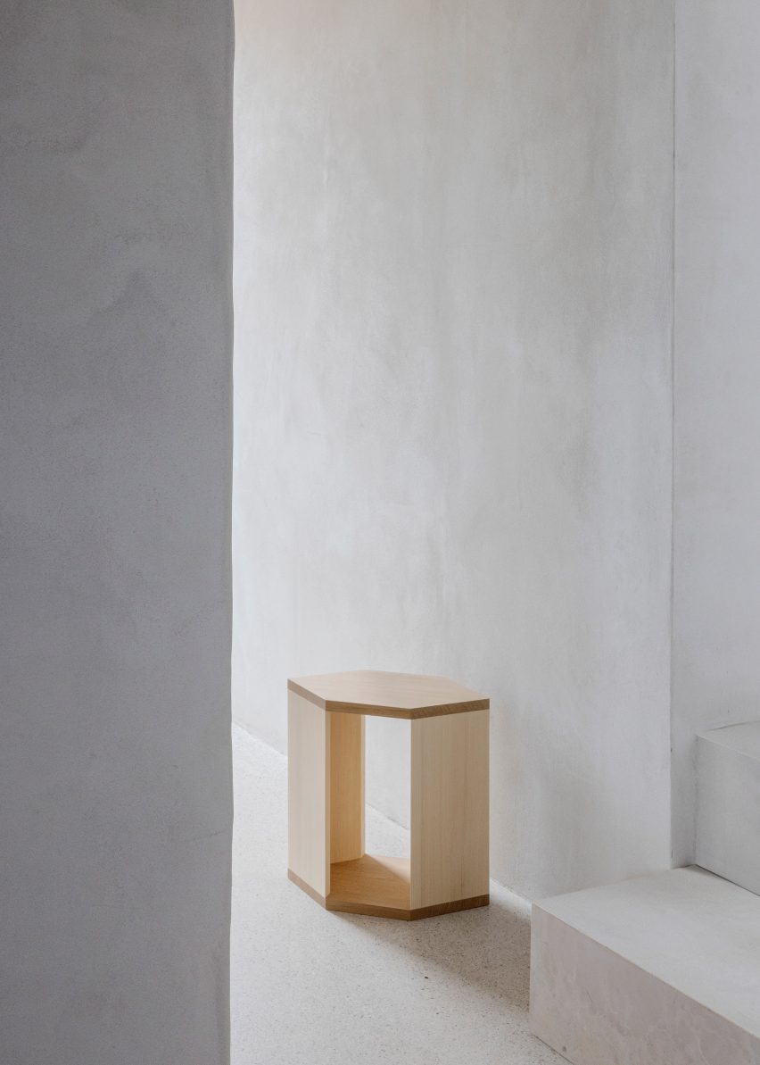 Wooden side table in white-walled interior