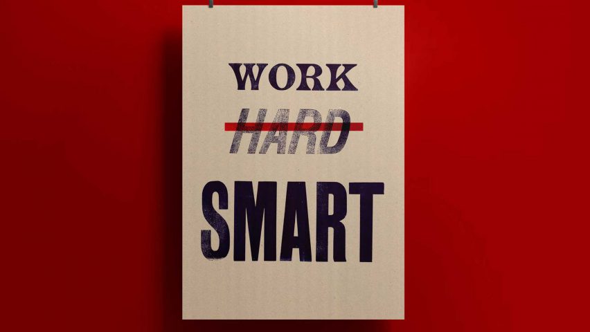 A photograph of a poster in tones of white against a red background, with the words 'work', 'hard' and 'smart' written on it in black text.