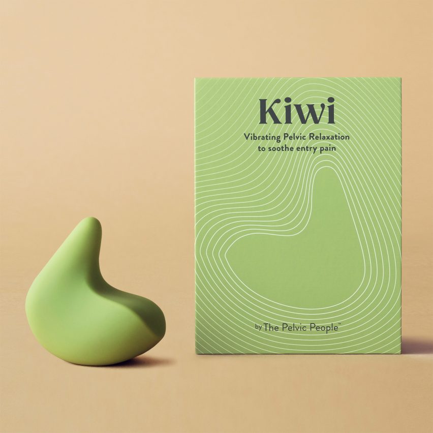A photograph of a vibrator, green in colour and in an abstract curved form, placed next to its box packaging in the same colour. The box has black text on it.