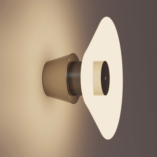 A photograph of a circular light, attached to a wall in tones of grey and brown.
