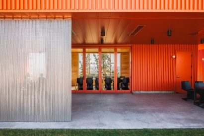 Red building with operable metal curtains