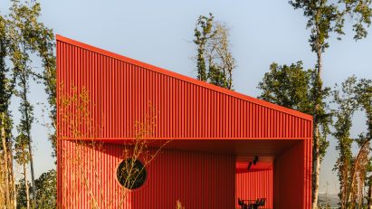 Red corrugated metal building with sloped roof