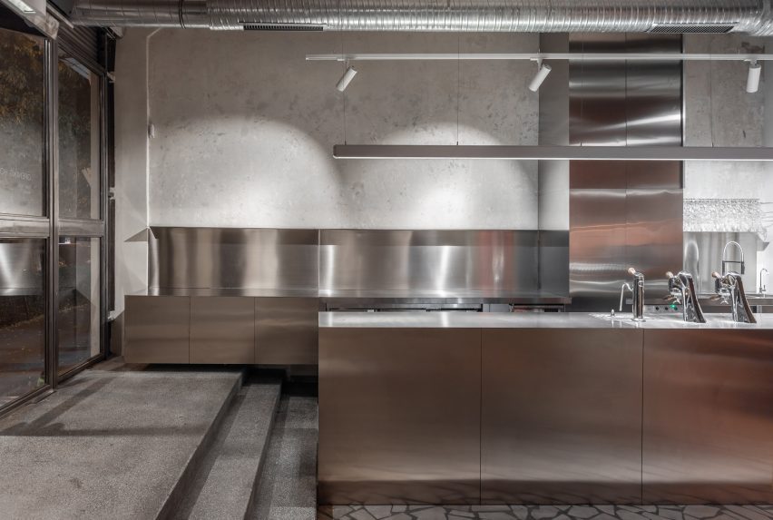 Steps leading down to polished stainless steel bar area