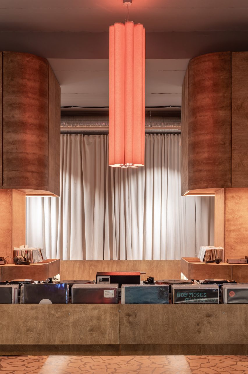 Orange light hanging from ceiling inside listening bar