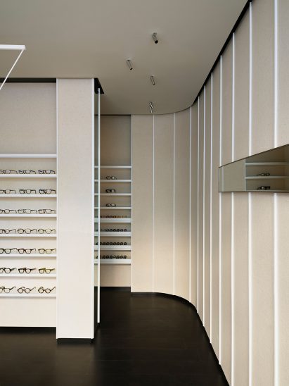 A beige felt wall curves behind a display partition