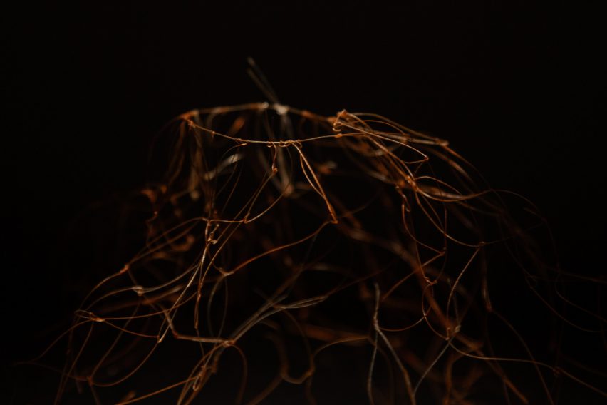 A photograph of a copper wire structure against a black backdrop.
