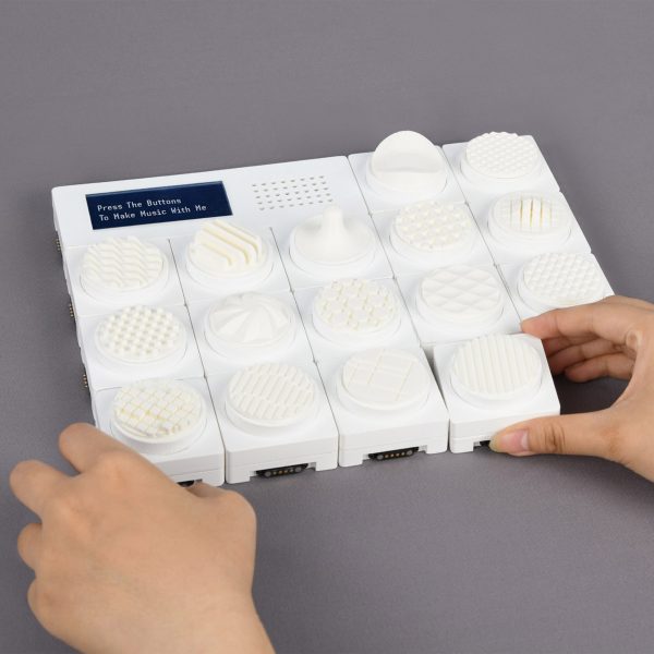 A photograph of a person's hands interacting with a design piece in tones of white