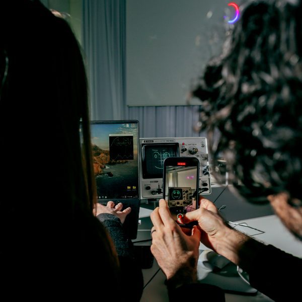 A photograph of two people taking a photograph on a smartphone.