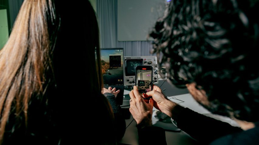 A photograph of two people taking a photograph on a smartphone.