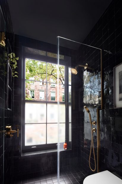 Bathroom lined with inky black zellige tiles