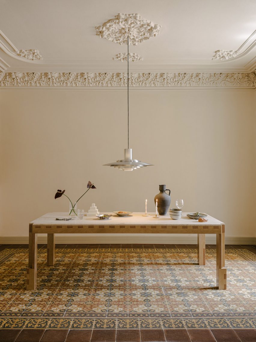 Large wooden table with silver ceiling light hanging down