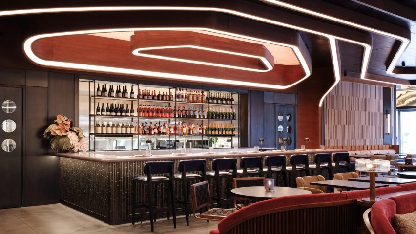 A photograph of a hotel bar in tones of red, beige and brown