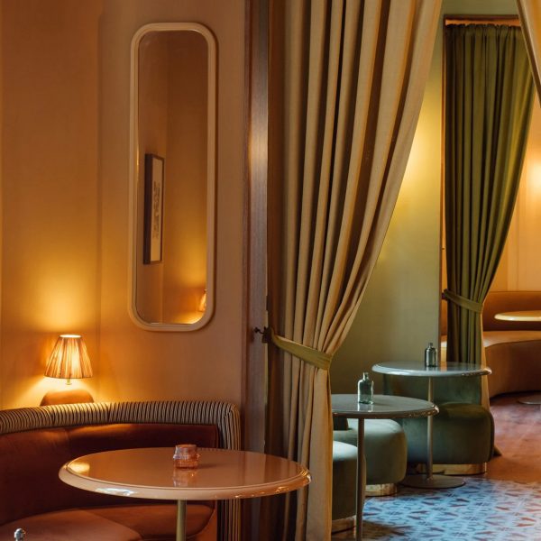 A photograph of an interior with large green curtains and warm yellow lighting.