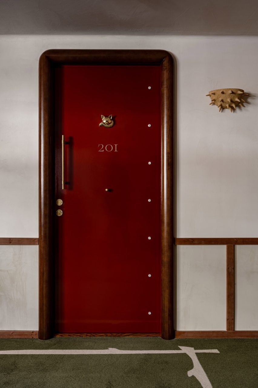 Red gloos door with wolf knocker and anenome wall light