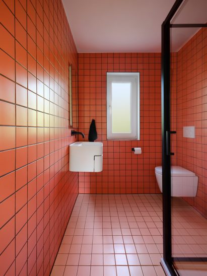 Red-tiled bathroom with glass door