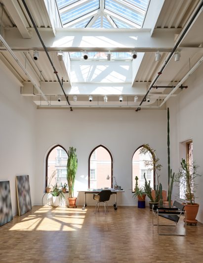 Artist's studio with exposed industrial beams and a skylight