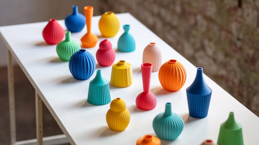 A photograph of small ceramic vases atop a white surface, in tones of blue, red, yellow, orange, pink and green.