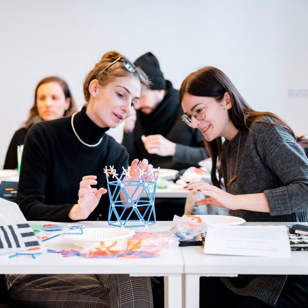 Two students discussing their design project with an architectural model in front of them