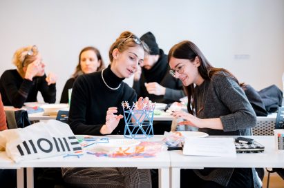 Two students discussing their design project with an architectural model in front of them