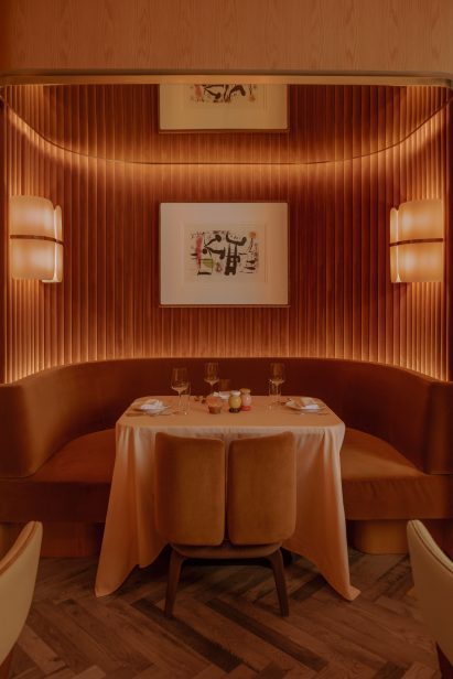 Banquettes within a niche lined with reeded velvet panels