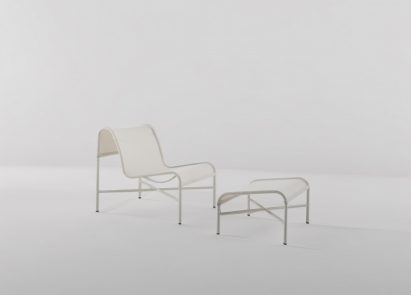 Photo of the Tensil chair by Lilian van Daal and Rianne Koens showing a slender curved metal frame with a light, sheer fabric stretched over it and a matching footrest, all in white