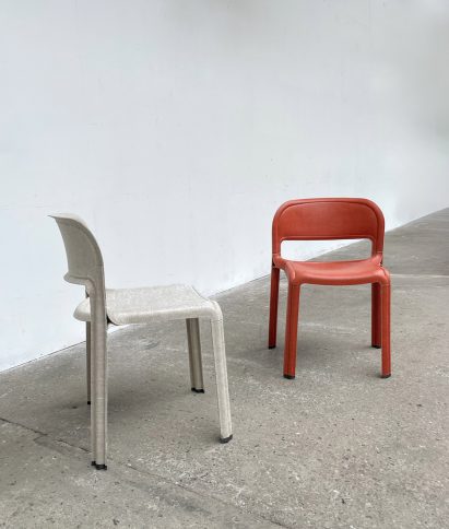A photograph of two chairs, one in tones of white and another in tones of red.