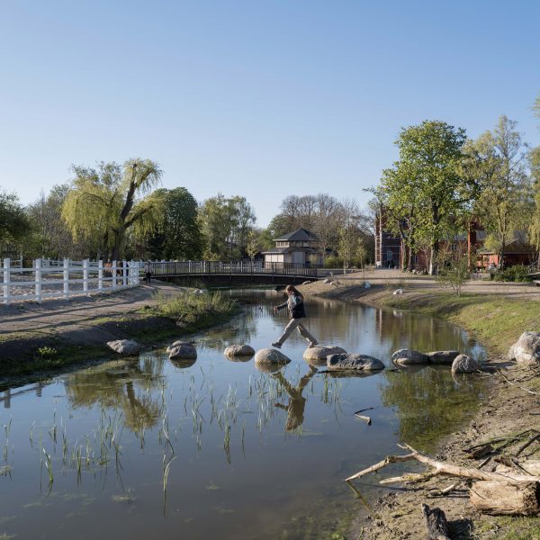 Person walking across pond within Karens Minde Axis park in Copenhagen