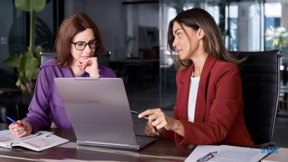 Two women using ThinkBook Plus Gen 6 Rollable in an office