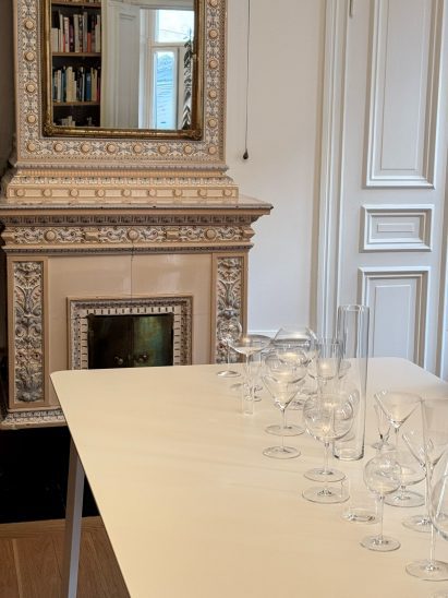 glasses on table in front of ornate ceramic fireplace