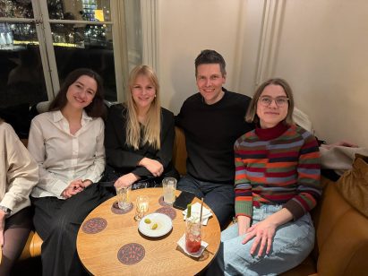 Four people sitting at a table with drinks