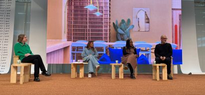 four people seated on stage in front of colourful backdrop