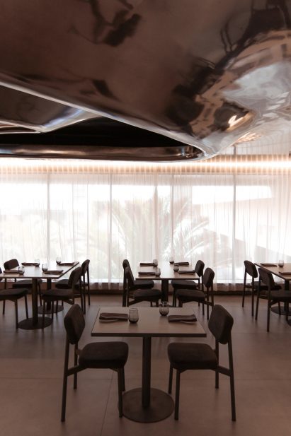 Sheer curtains covering full-height windows in a restaurant