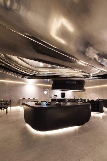 A metallic ceiling with a rippled relief over a food preparation area