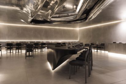 Black island with bar seating in the centre of a dining room