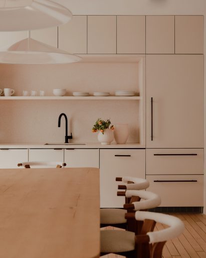 Kitchen with pale millwork and stone backsplash