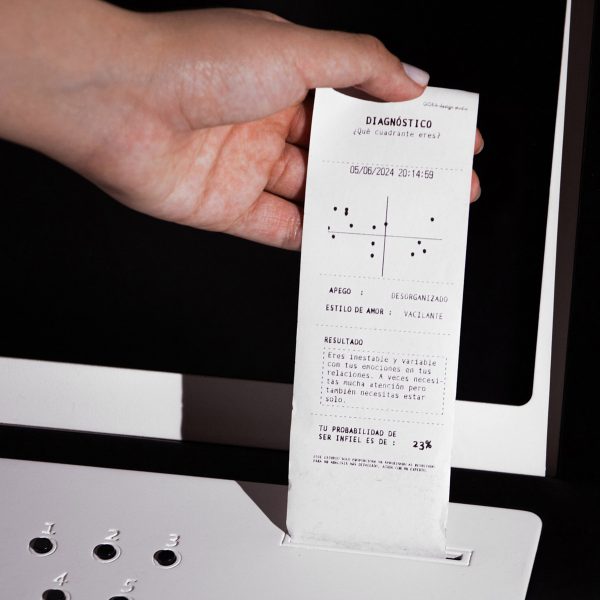 A photograph of a person's hand pulling a paper receipt out of a till in tones of white and black.