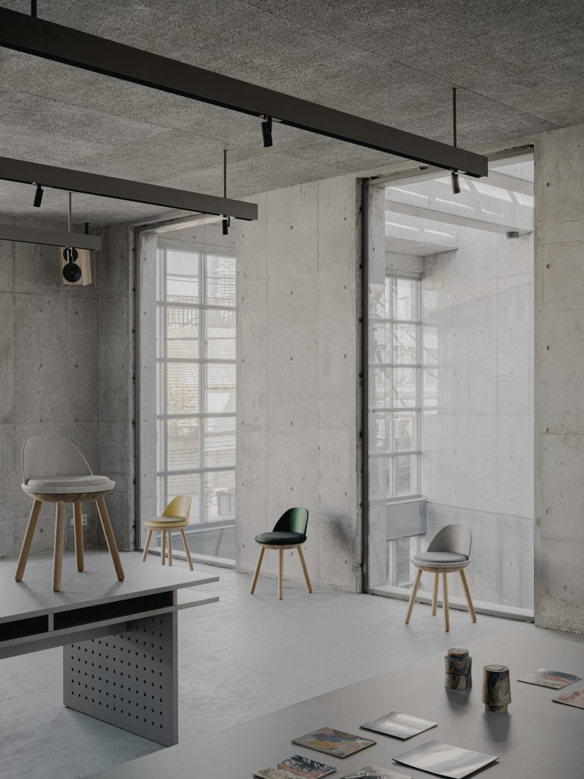 Concrete room with internal windows overlooking atrium