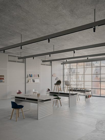 Desks and chairs in concrete room with gridded glass windows