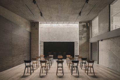 Chairs lined up in front of screen in concrete room