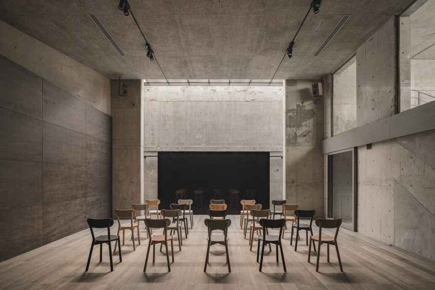 Chairs lined up in front of screen in concrete room