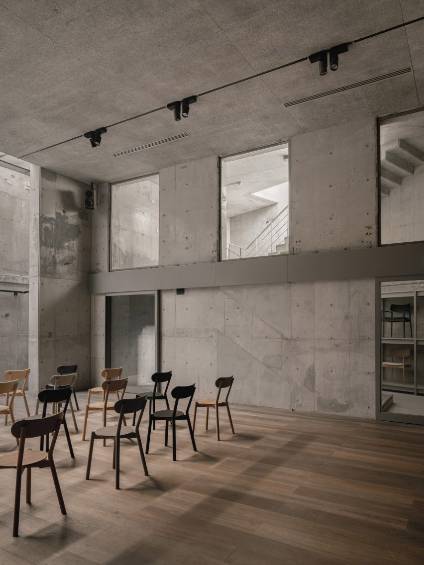 Chairs lined up in concrete hall with wooden floor
