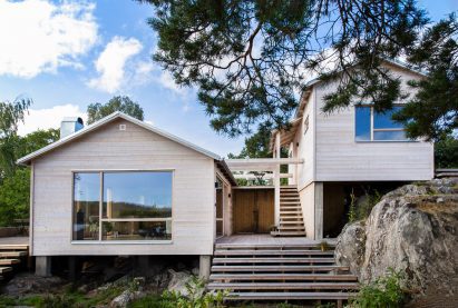 Two wooden houses joined by a pergola