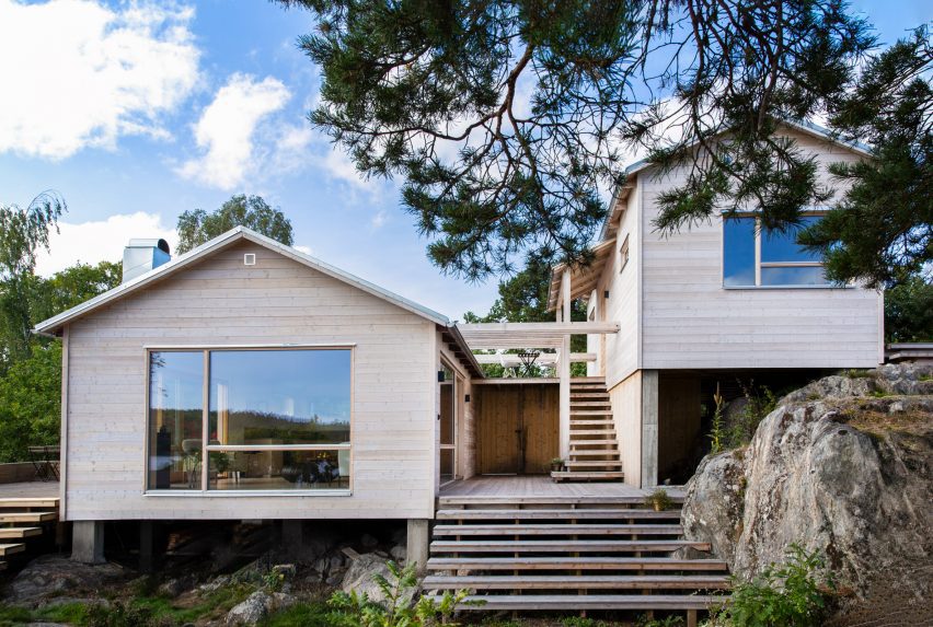 Two wooden houses joined by a pergola