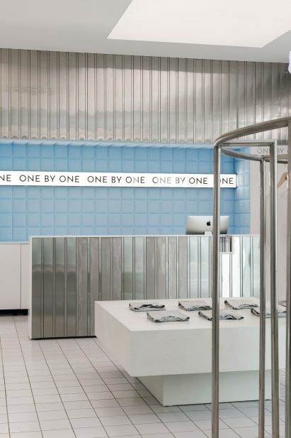 Store interior with aluminium wall panels and pale blue padding behind the service counter