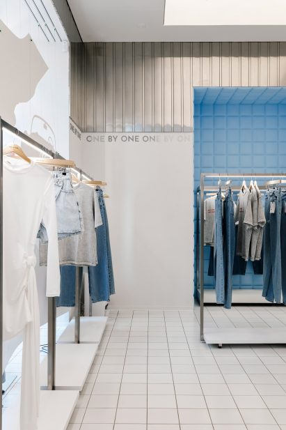 Clothing store with white tiled floors and aluminium wall panels