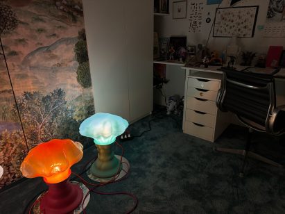 Two floors lights in front of a fabric screen