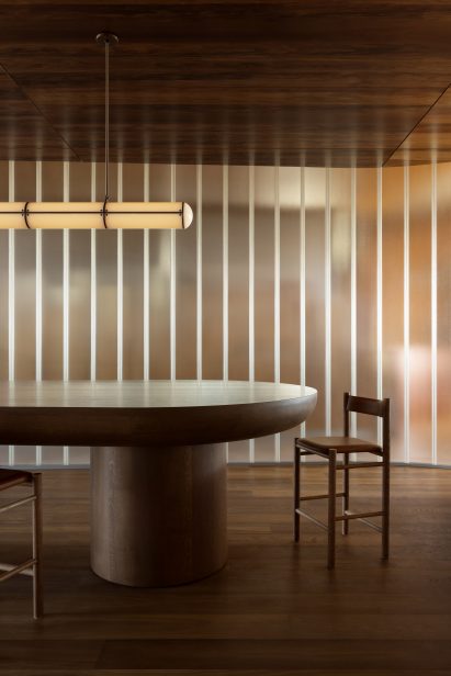 Chair and table in front of lit glass wall