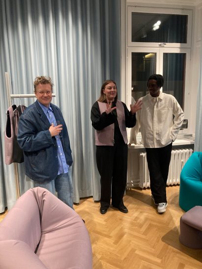 Three people stood in front of a curtain