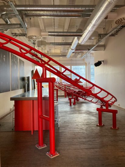 Red rollercoaster tracks inside office space