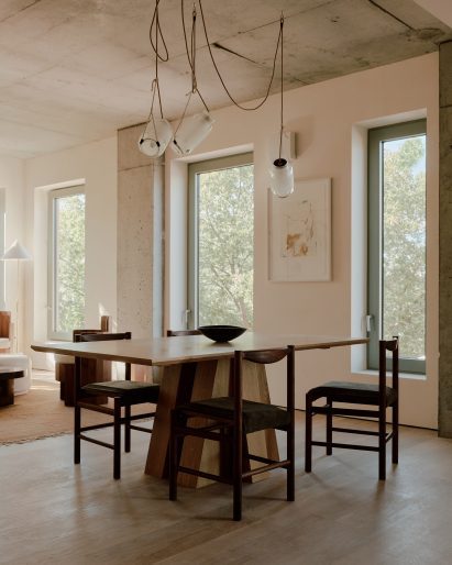 Dining room with wooden table under a pendant light hung from ropes